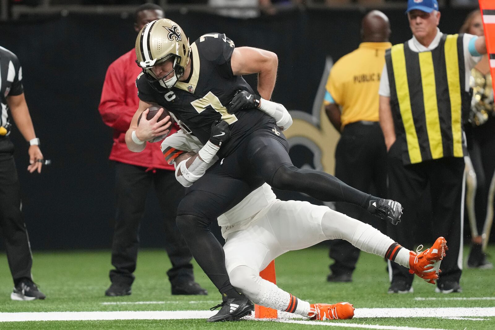 New Orleans Saints tight end Taysom Hill (7) is brought down by Cleveland Browns safety Juan Thornhill, rear, as he scores in the first half of an NFL football game in New Orleans, Sunday, Nov. 17, 2024. (AP Photo/Gerald Herbert)