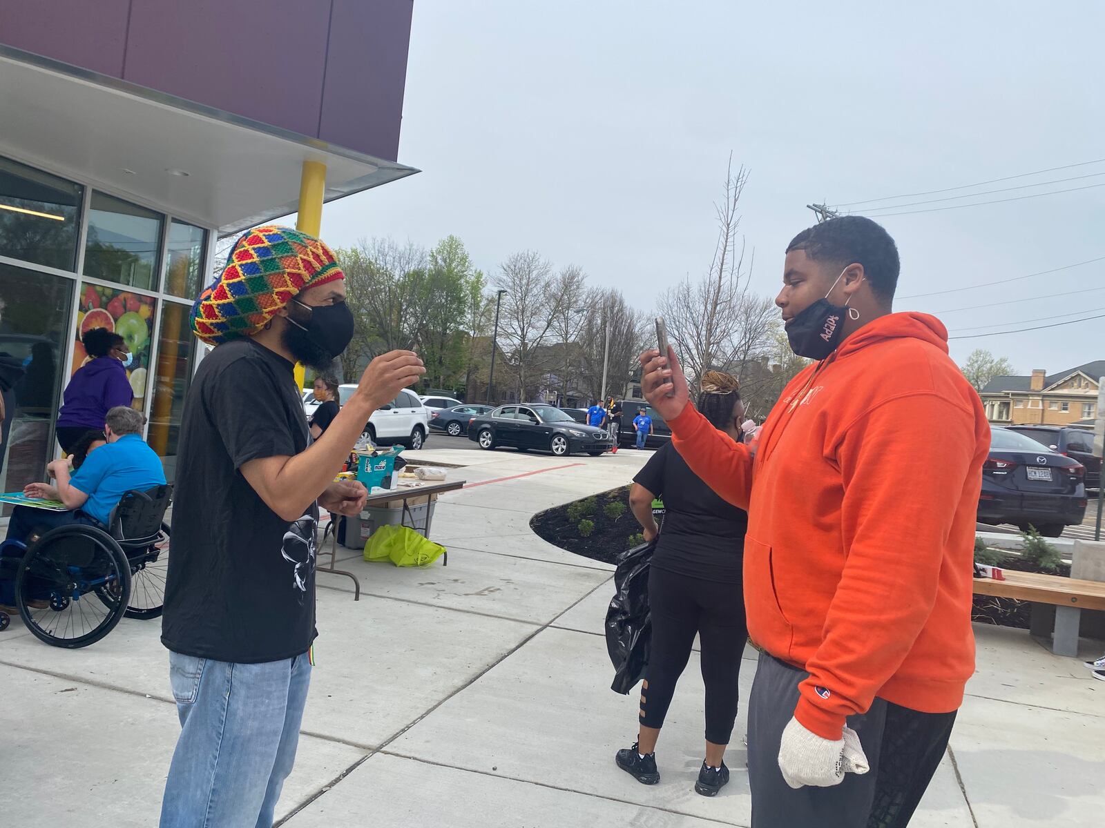 Amaha Sellassie (left), president of the Gem City Market board, makes a video with Chaz Amos, CEO of I Love West Dayton. EILEEN McCLORY / STAFF