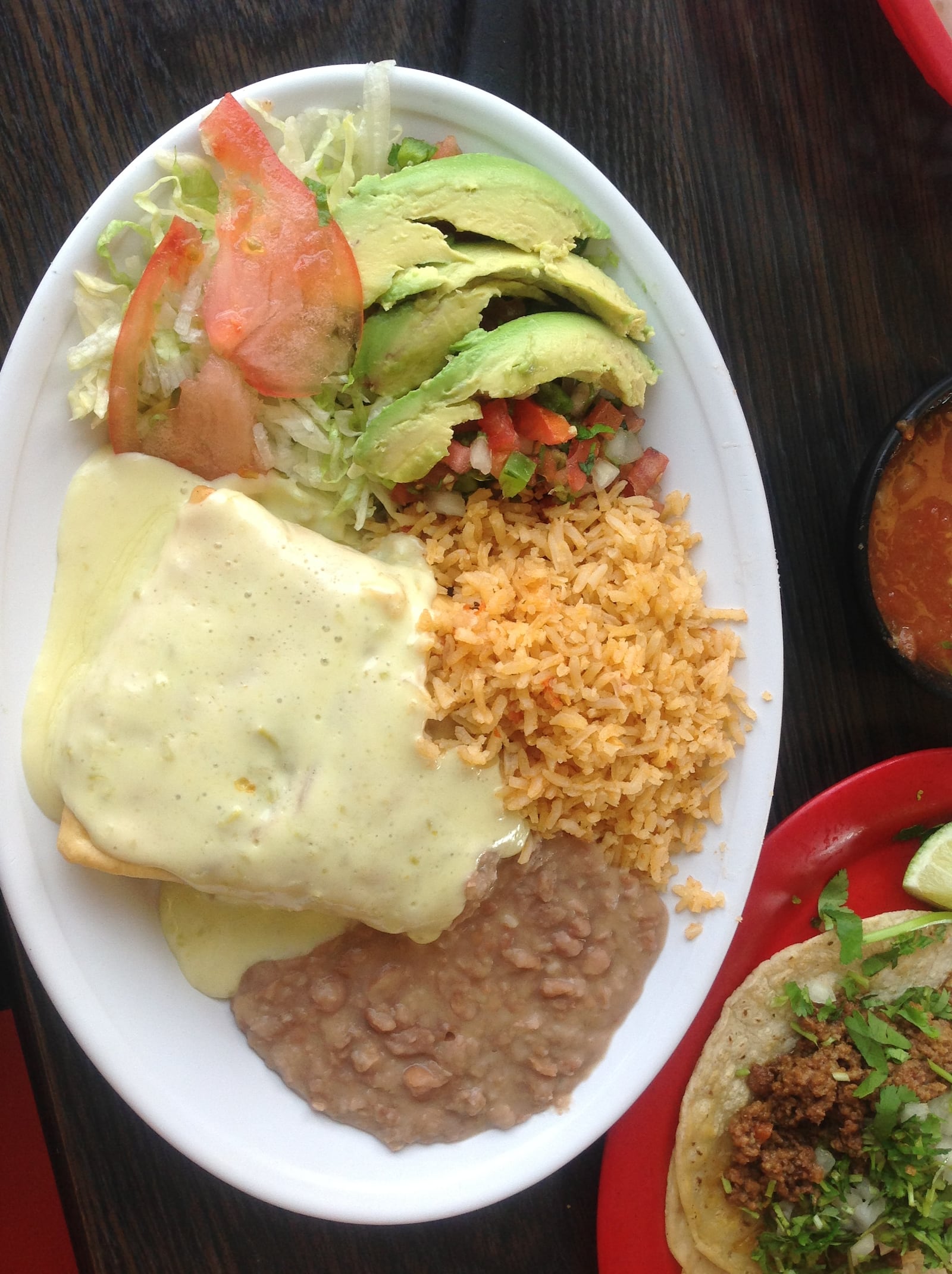 Taqueria Mixteca’s chimichanga - a deep fried tortilla filled with meat - comes with cheese sauce, a salad, pico de gallo and rice and beans. The dish is $7.99. (Staff photo by Amelia Robinson)