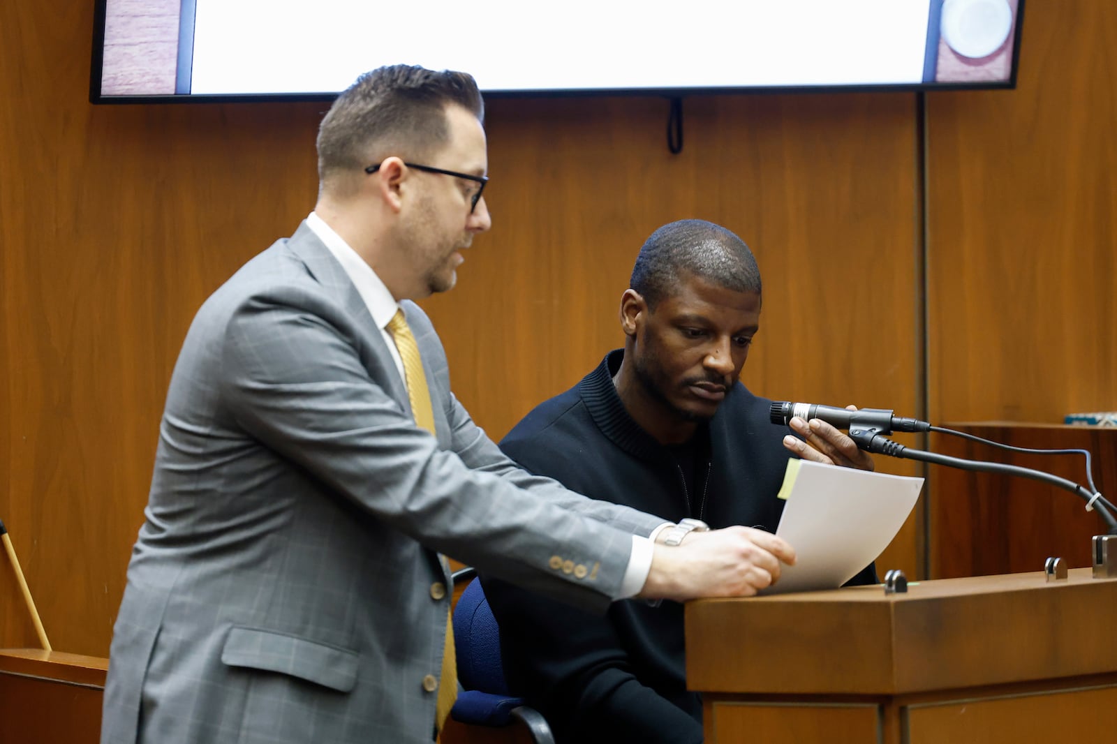 Los Angeles County Deputy District Attorney Paul Przelomiec, left, shows a document to A$AP Relli during A$AP Rocky's trial at the Clara Shortridge Foltz Criminal Justice Center in Los Angeles, Wednesday, Jan. 29, 2025. (Frazer Harrison/Pool via AP)