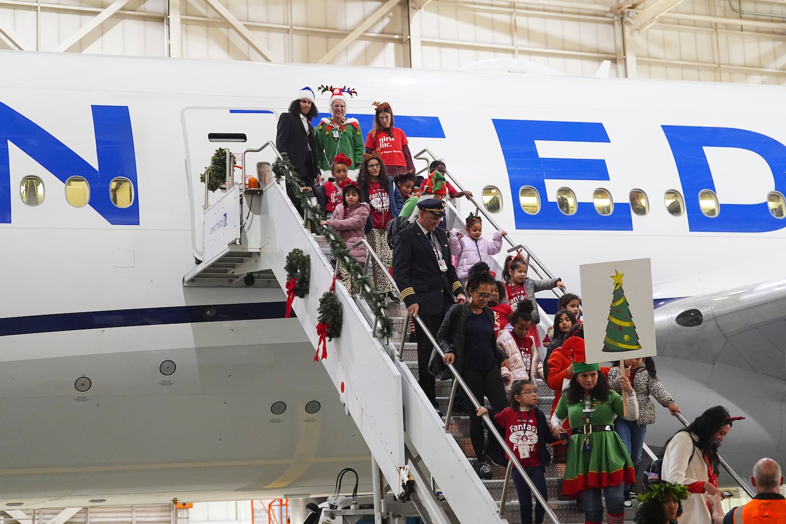 Participants deplane during the United Airlines annual "fantasy flight" to a fictional North Pole at Denver International Airport, Saturday, Dec. 14, 2024, in Denver. (AP Photo/David Zalubowski)