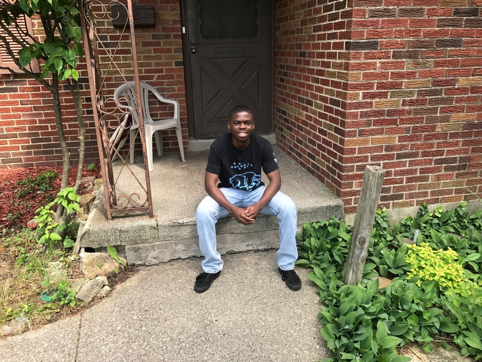 Bibebibyo Seko sits on the porch of his home in the Hillcrest area of North Dayton. TOM ARCHDEACON / STAFF