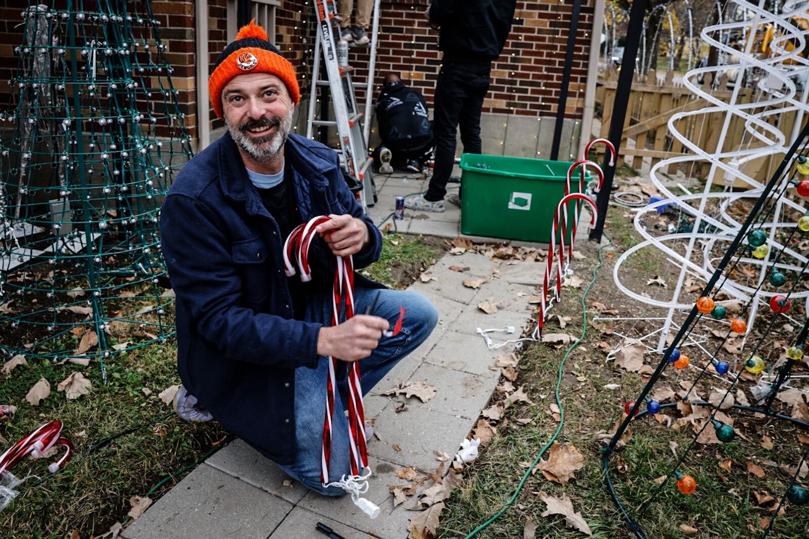 Wonderly Avenue homeowner, Josiah Templeton installs Christmas lights on his house Monday. Templeton said he and girlfriend Jesicca Myers are getting pushback from the city of Oakwood for the elaborate display, which has included archways over the sidewalk. JIM NOELKER/STAFF