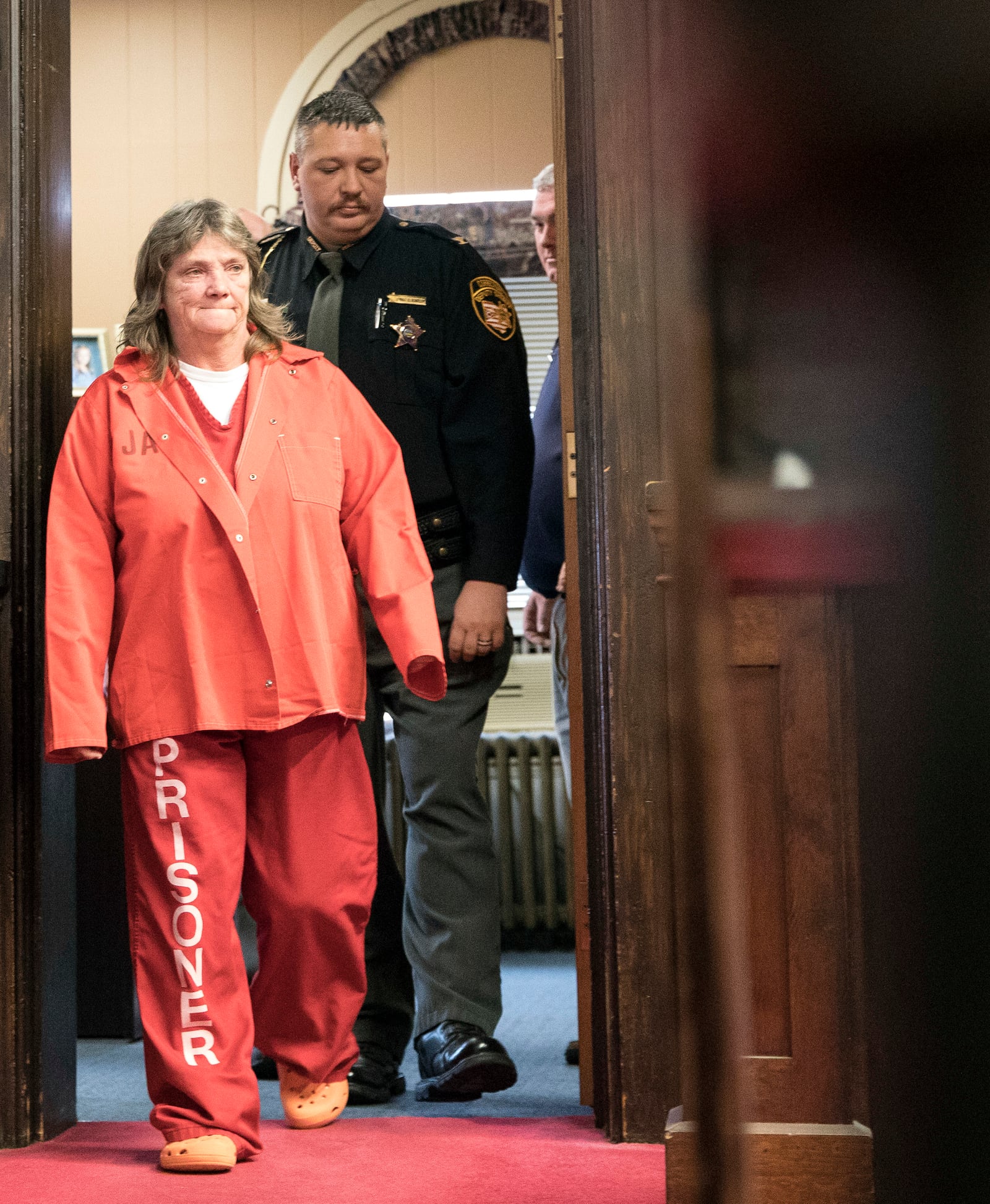 FILE - Rita Newcomb, of South Webster, is escorted into Judge Randy Deering's Pike County courtroom in Piketon, Ohio, Nov. 15, 2018, for her arraignment regarding her possible involvement in the murder of the Rhoden family in 2016. (Robert McGraw/The Chillicothe Gazette via AP, File)