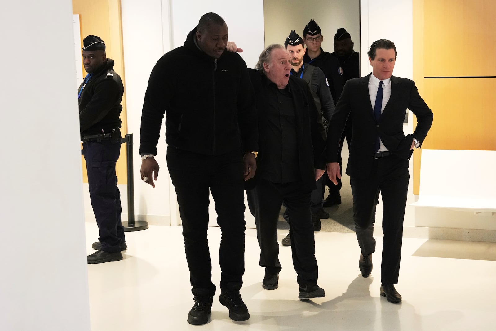 Actor Gerard Depardieu reacts as he leaves the courtroom for a break with his lawyer Jeremie Assous during his trial for the alleged sexual assaults of two women on a film set in 2021, Tuesday, March 25, 2025 in Paris. (AP Photo/Aurelien Morissard)