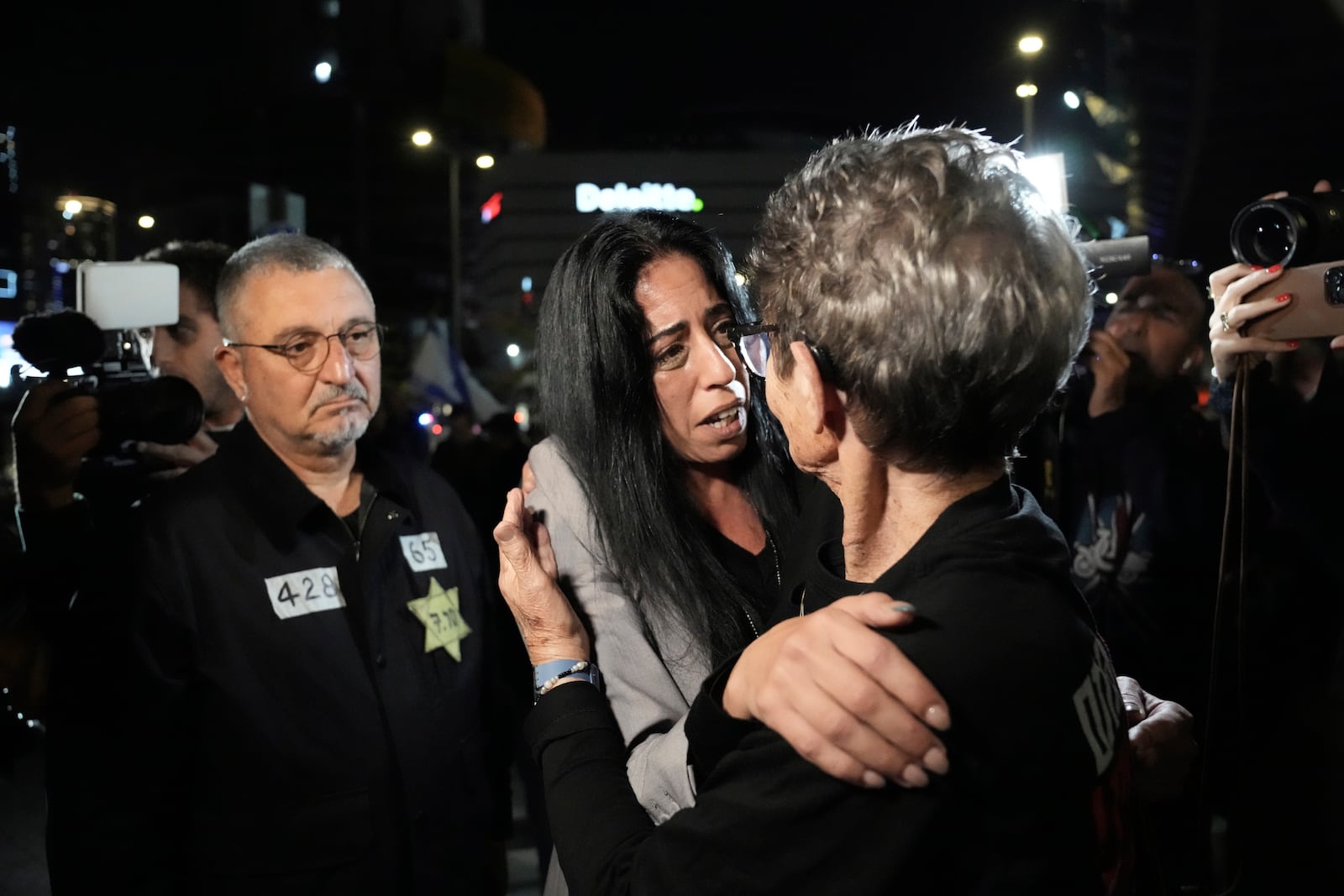 FILE - Einav Zangauker, center, is embraced by freed hostage Yocheved Lifshitz before making a statement about a Hamas video of her son, Israeli hostage Matan Zangauker, in Tel Aviv, Israel, Saturday, Dec. 7, 2024. (AP Photo/Mahmoud Illean, File)