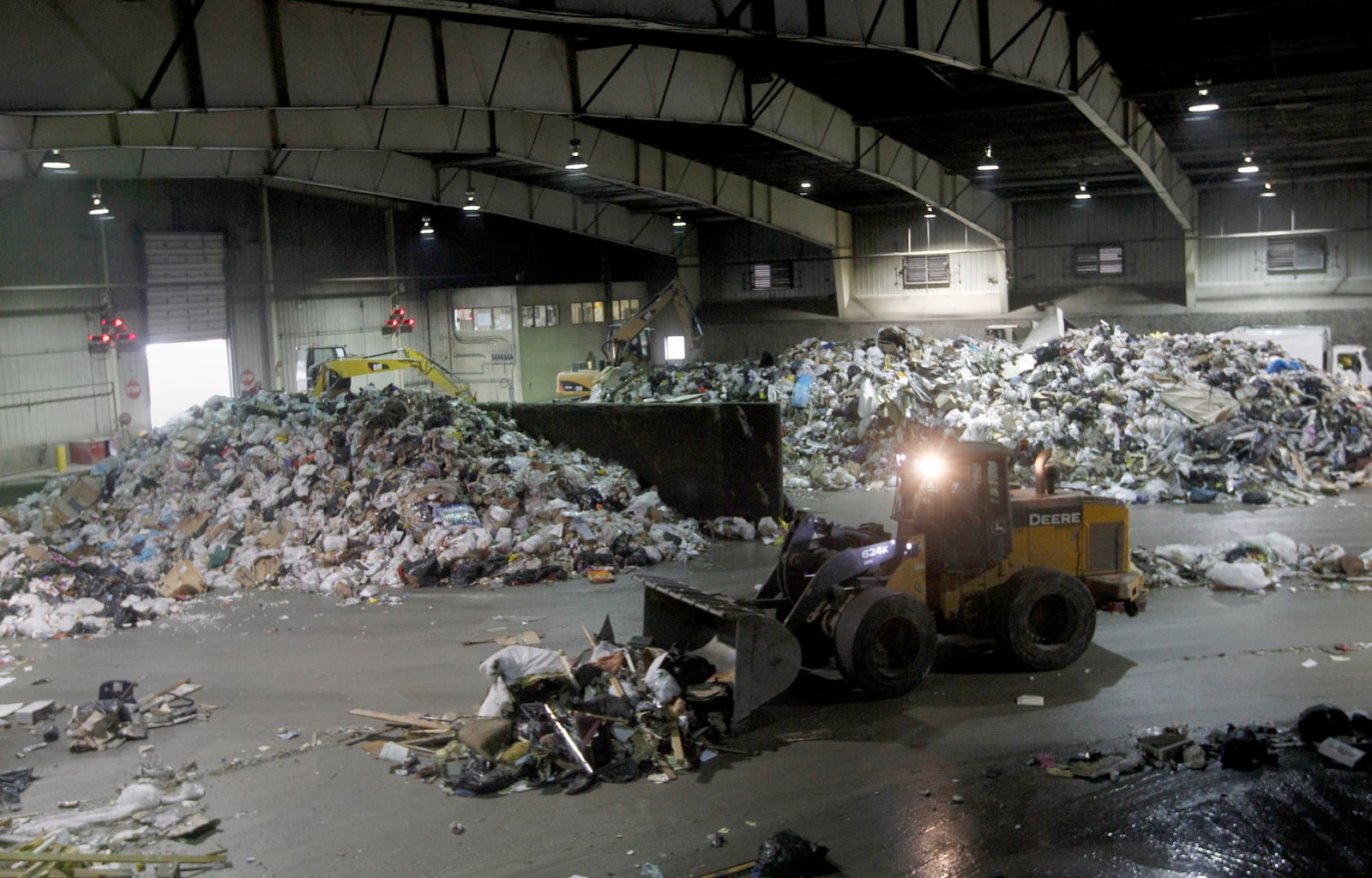 Heavy equipment moves piles of trash on the tipping floor at the Montgomery County Solid Waste transfer station in Moraine.   LISA POWELL / STAFF