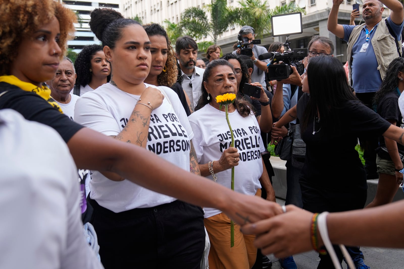 Mother of slain councilwoman Marielle Franco, Marinete Silva, right center, and Luyara Santos, left center, daughter of slain councilwoman Marielle Franco, accompanied by other family members, arrive to follow the trial of former city councilwoman Marielle Franco's alleged killers, in Rio de Janeiro, Brazil, Wednesday, Oct. 30, 2024. (AP Photo/Silvia Izquierdo)