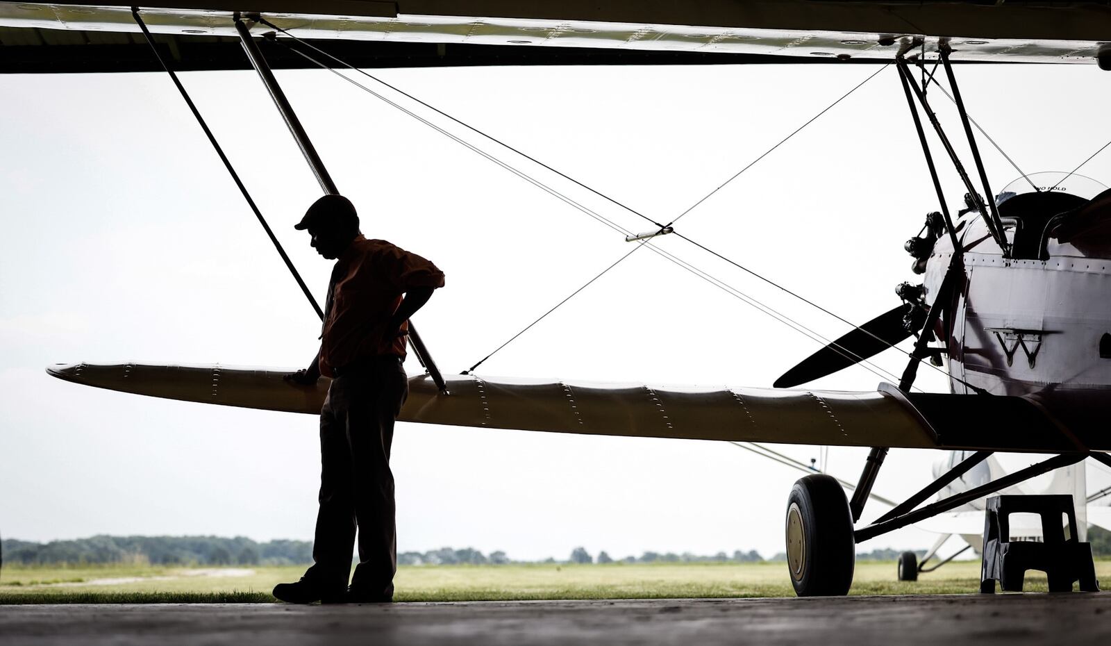 Dewey Davenport stands near one of his 1930s vintage biplanes in his hanger near Jamestown. .Davenport says he is a “true barnstormer,” because he travels from town to town to give plane rides, just like the barnstormers did in the early 20th century.   JIM NOELKER/STAFF