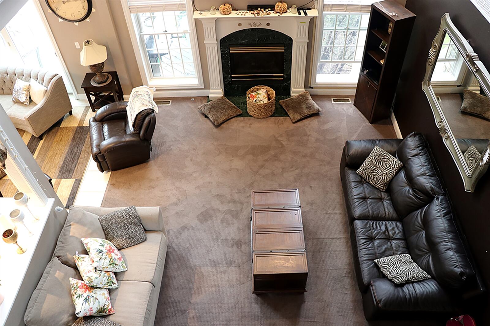 A gas fireplace with fluted wood mantel is the centerpiece of the great room. Two tall windows flank the fireplace and wrought-iron railing accents the second-floor catwalk. CONTRIBUTED PHOTO BY KATHY TYLER