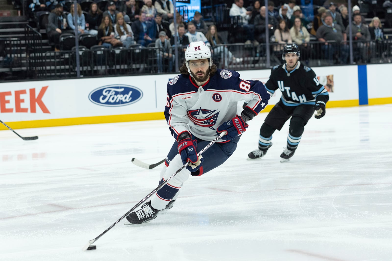 Columbus Blue Jackets right wing Kirill Marchenko (86) skates with the puck against Utah Hockey Club center Alexander Kerfoot (15) during the first period of an NHL hockey game Friday, Jan. 31, 2025, in Salt Lake City. (AP Photo/Melissa Majchrzak)