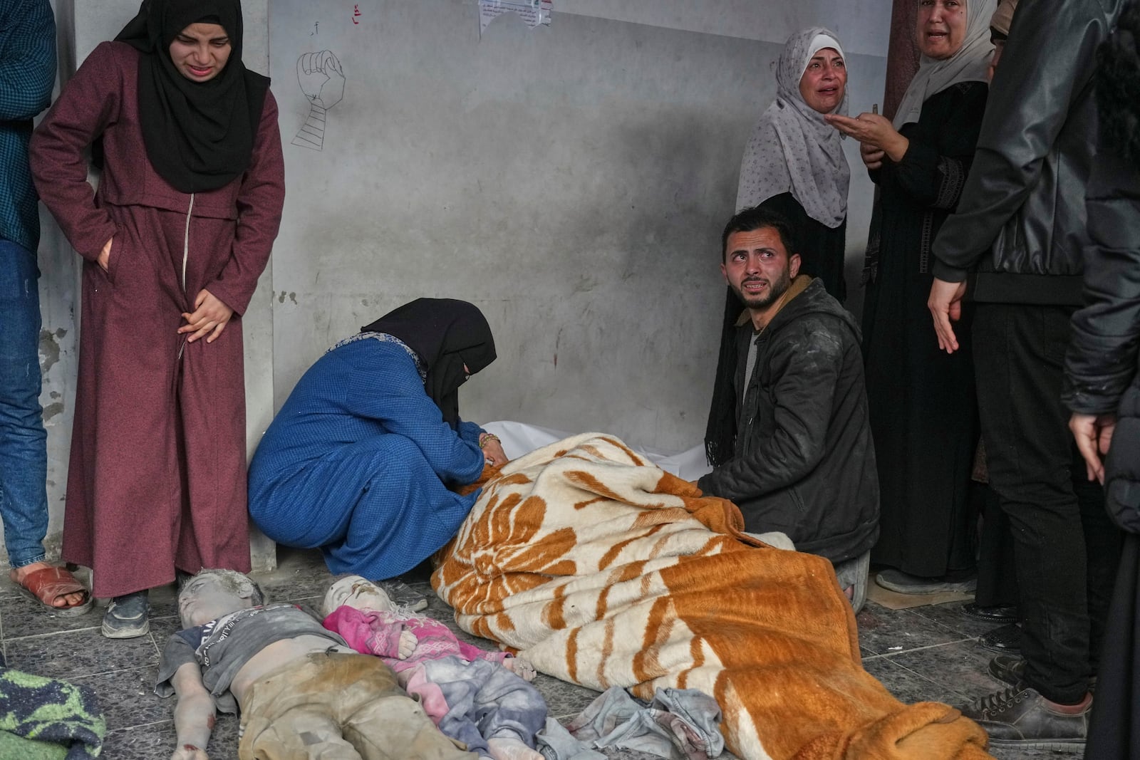 EDS NOTE GRAPHIC CONTENT.- A woman mourns over the body of a person killed in overnight Israeli army airstrikes across the Gaza Strip, at the Al-Ahli hospital in Gaza City, Tuesday, March 18, 2025. (AP Photo/Jehad Alshrafi)