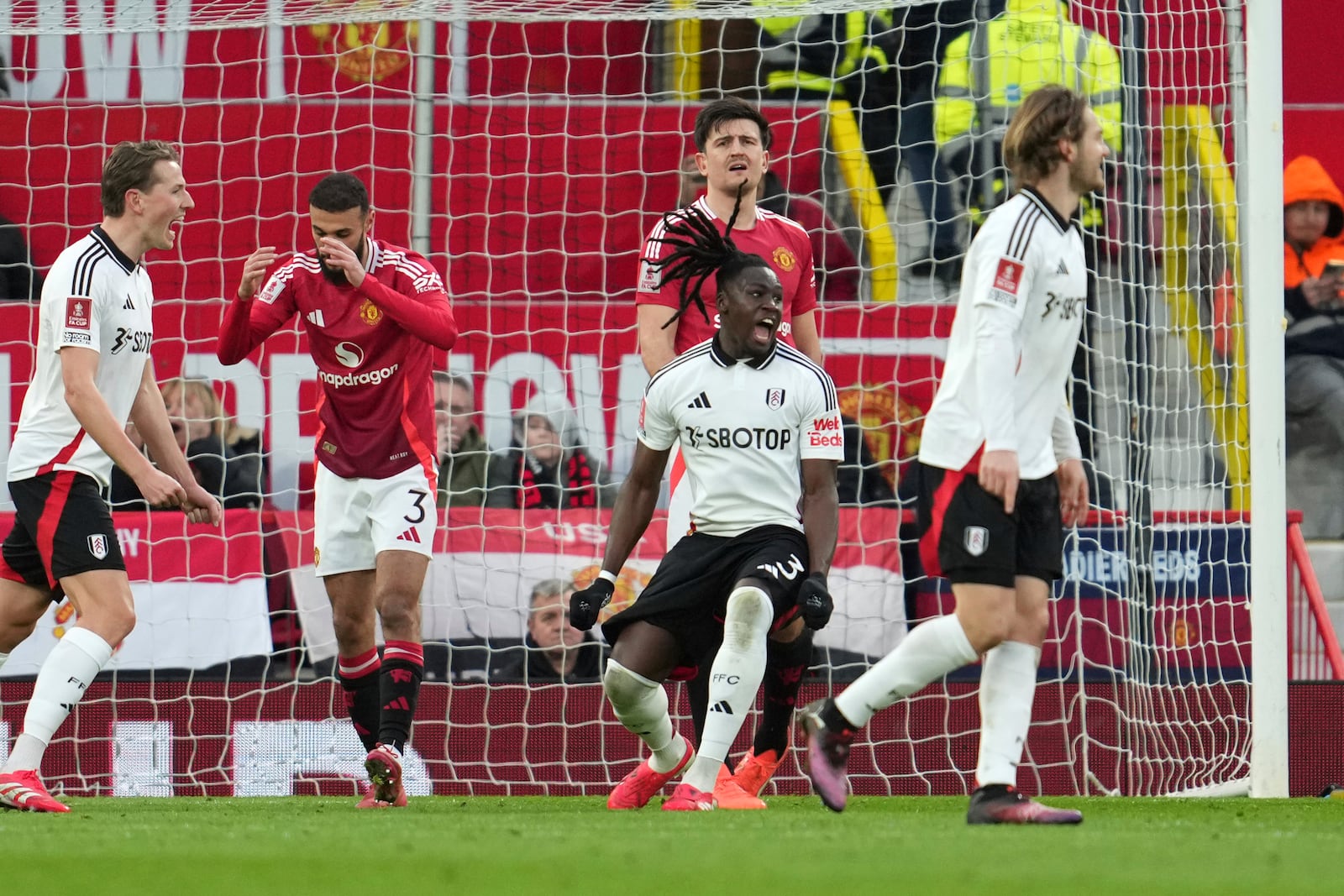 Fulham's Calvin Bassey, centre, celebrates after scoring his side's opening goal during the English FA Cup soccer match between Manchester United and Fulham at the Old Trafford stadium in Manchester, England, Sunday, March 2, 2025. (AP Photo/Jon Super)