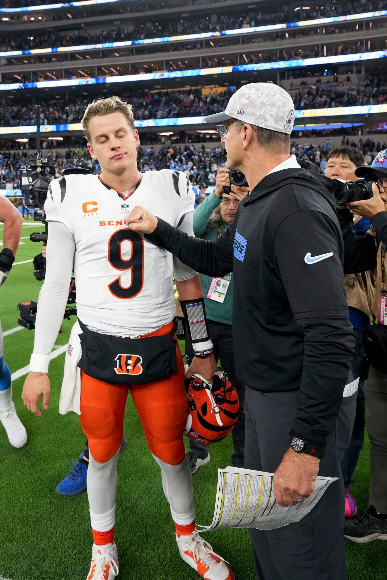 Los Angeles Chargers head coach Jim Harbaugh talks to Cincinnati Bengals quarterback Joe Burrow after an NFL football game Sunday, Nov. 17, 2024, in Inglewood, Calif. (AP Photo/Gregory Bull)