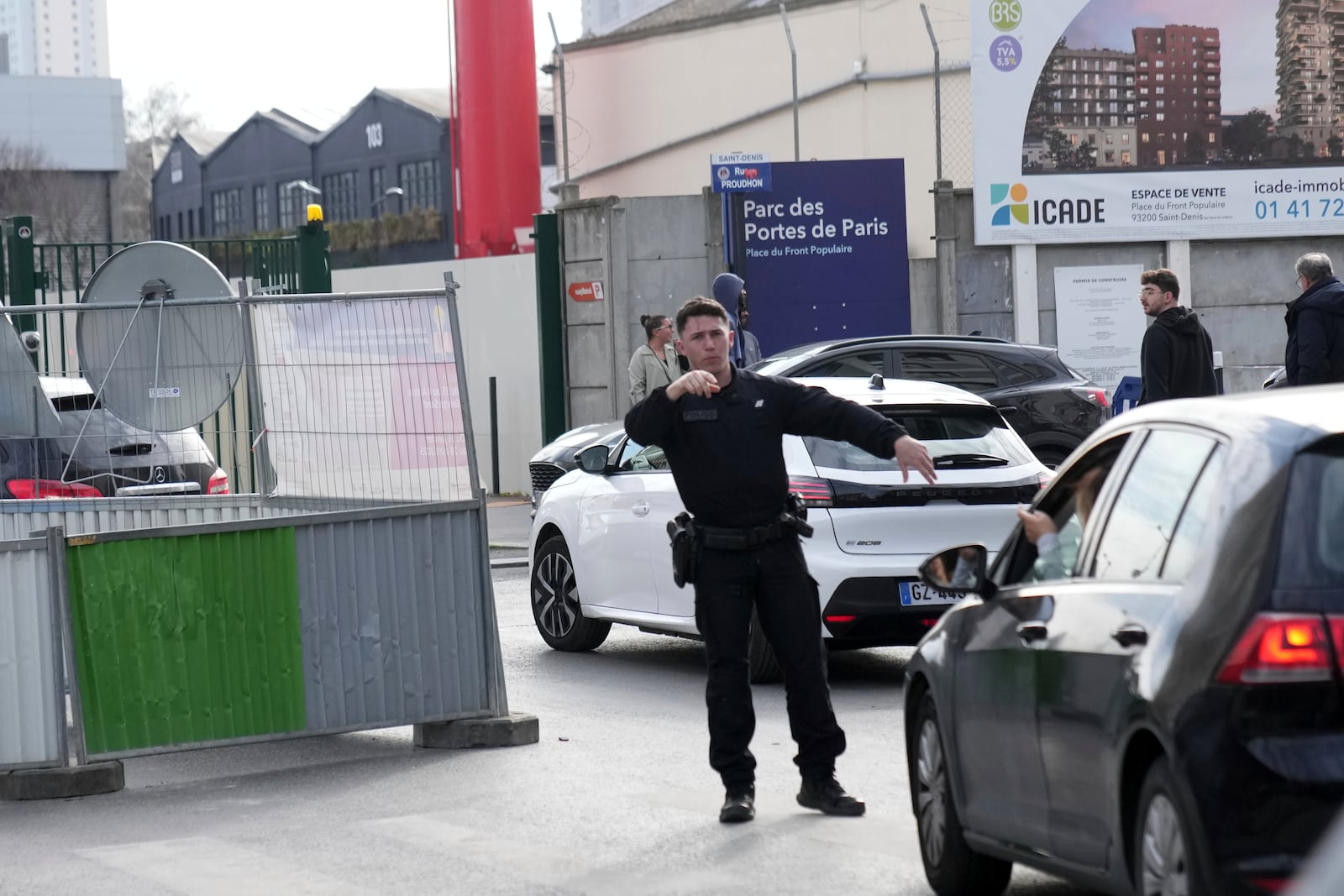 A police officer directs the traffic after the discovery of a huge unexploded World War II-era bomb caused transportation chaos in Paris, that included the suspension of high-speed rail links with London and Brussels and the closure of a vital road artery in the French capital Friday, March 7, 2025 in Saint-Denis, outside Paris. (AP Photo/Christophe Ena)