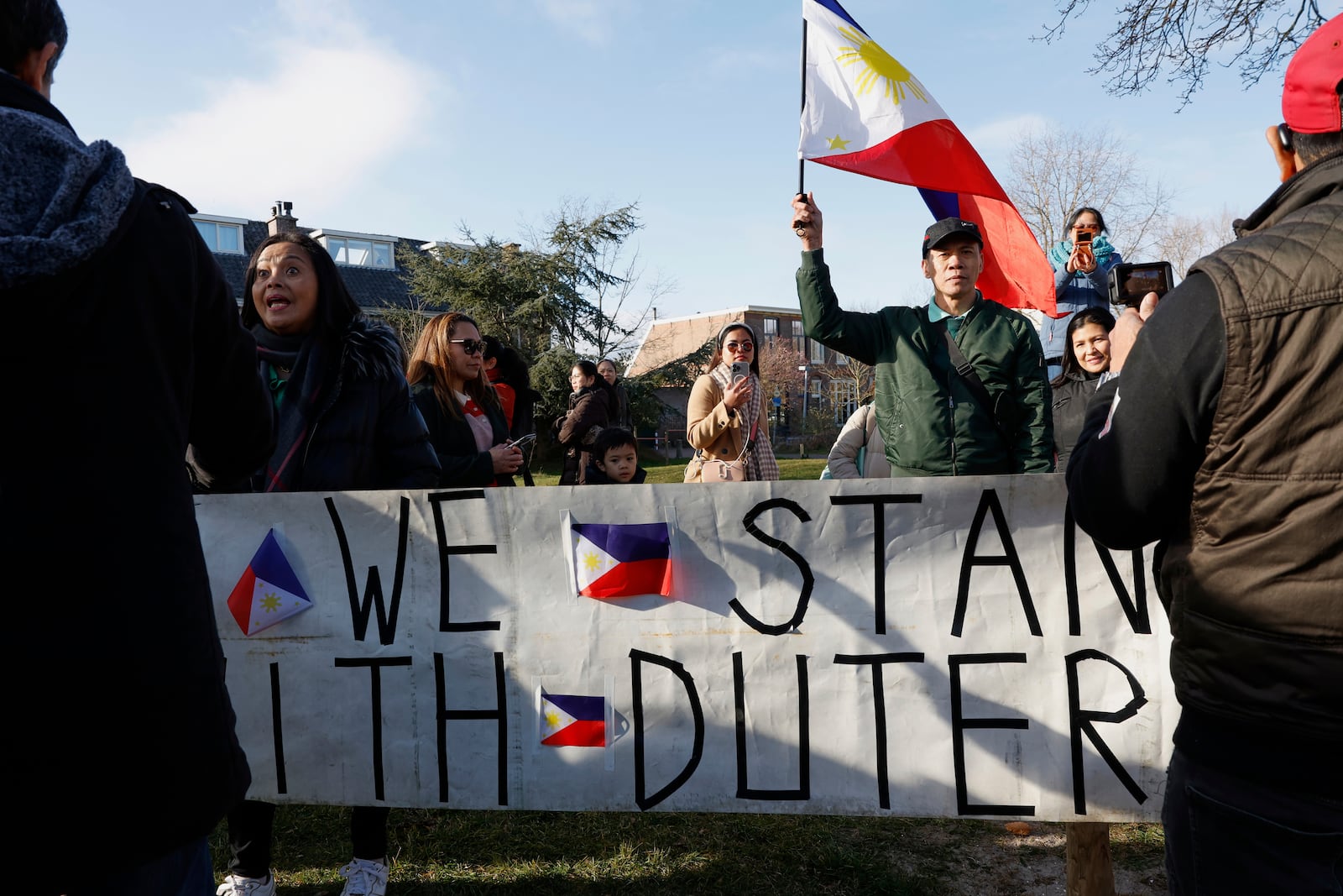 A supporter of former Philippine President Rodrigo Duterte waves a flag as he demonstrates outside the International Criminal Court detention center near The Hague in Scheveningen, Netherlands, Wednesday, March 12, 2025. (AP Photo/Omar Havana)