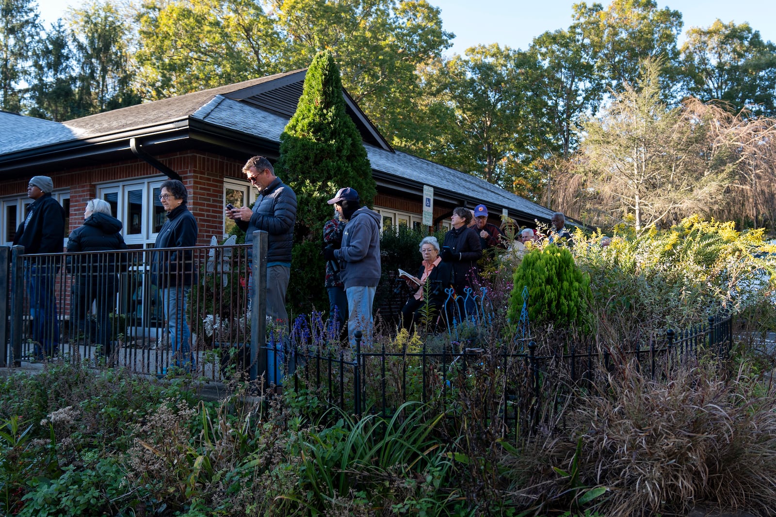 People wait in line at the polling place at Skyland/South Buncombe Library in Asheville, N.C. during the first day of early in-person voting, on Oct. 17, 2024. (AP Photo/Stephanie Scarbrough)