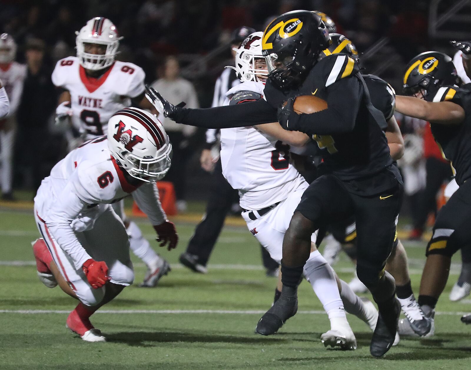 Centerville's Emable Wakilongo tries to avoid a tackle by Wayne's Joshua Williams-West during Friday's game. BILL LACKEY/STAFF