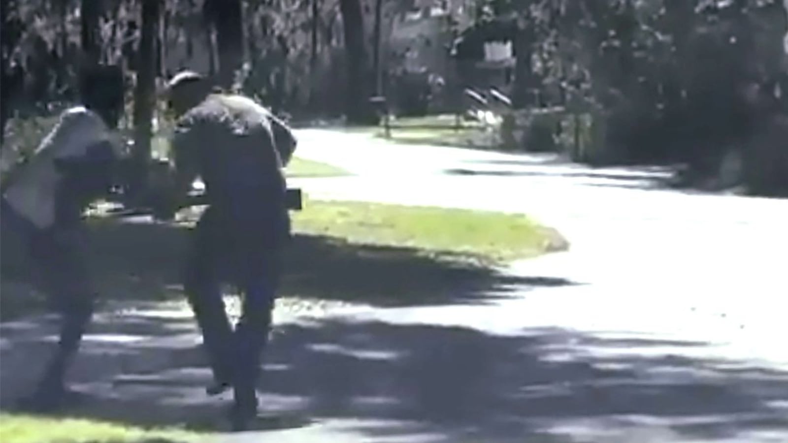 In this image from video posted on Twitter Tuesday, May 5, 2020, Ahmaud Arbery, left, struggles with Travis McMichael over a shotgun on a street in a neighborhood outside Brunswick, Ga., on Feb. 23, 2020. Arbery, who was jogging when he was confronted by McMichael and his father, a former police officer, was shot multiple times. The 25-year-old died at the scene. (Twitter via AP)