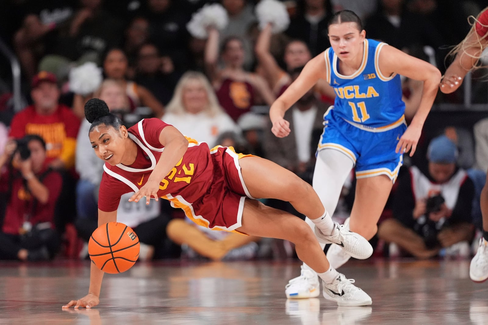 Southern California guard JuJu Watkins, left, slips while dribbling as UCLA guard Gabriela Jaquez defends during the first half of an NCAA college basketball game, Thursday, Feb. 13, 2025, in Los Angeles. (AP Photo/Mark J. Terrill)