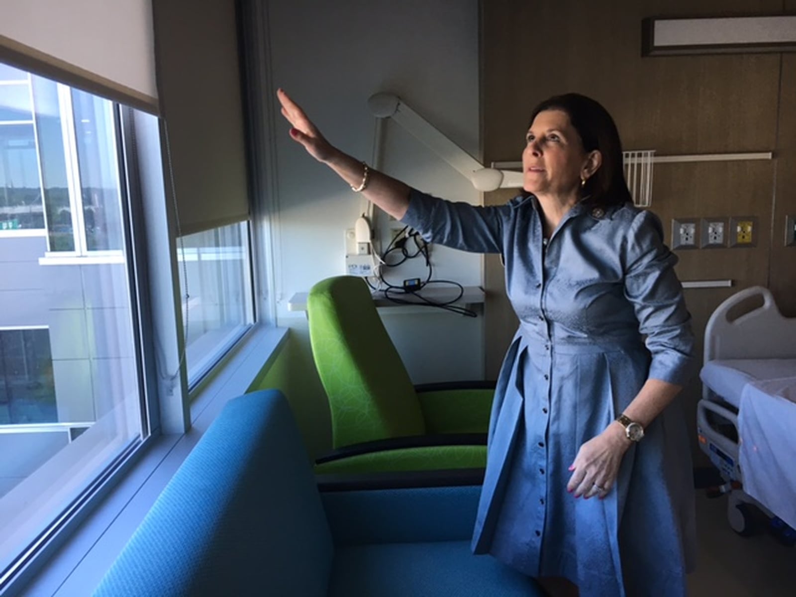 Deborah Feldman, president and CEO of Dayton Children’s Hospital, raises the shades in a new patient/family room in the hospital’s new patient tower. THOMAS GNAU/STAFF