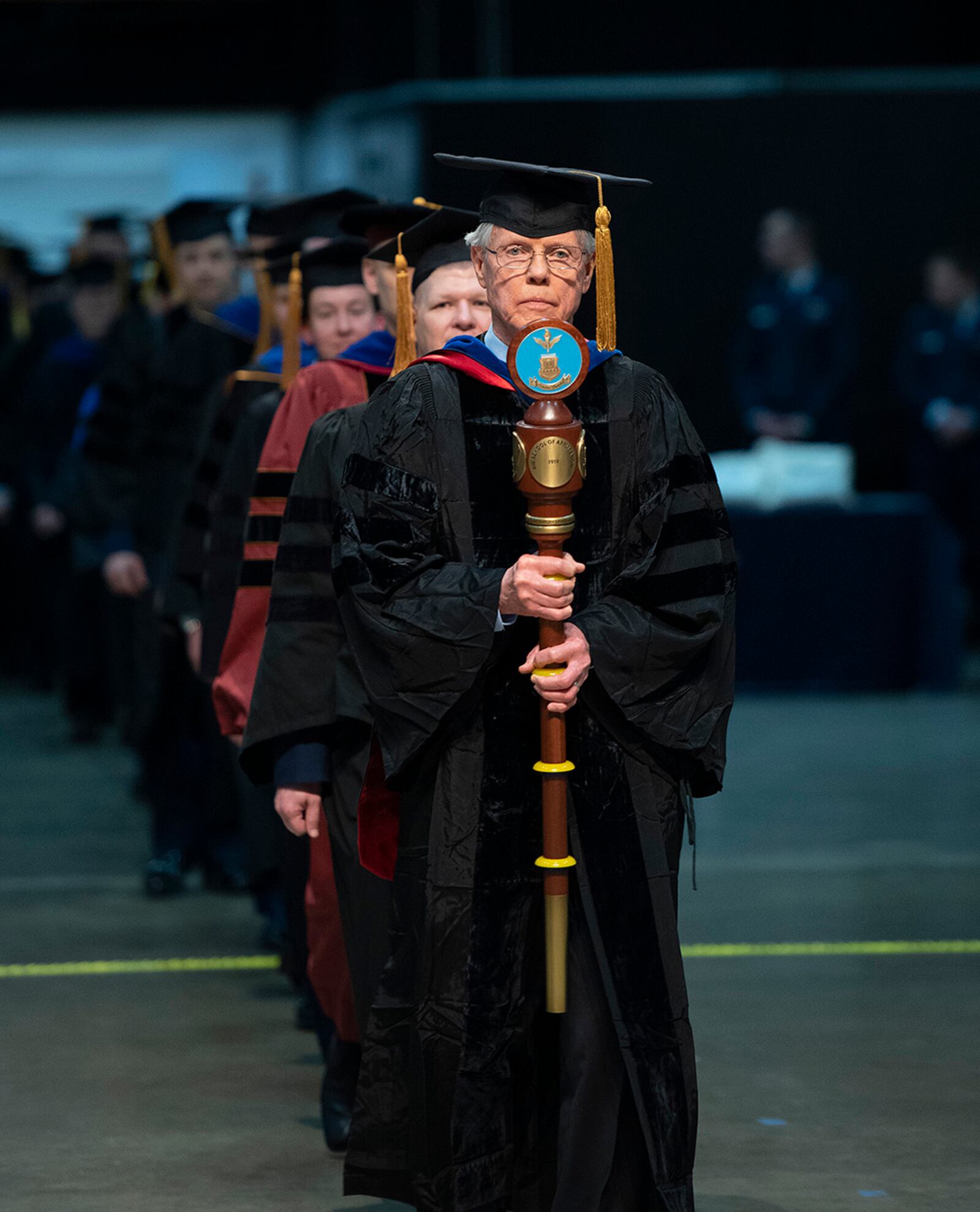 Dr. Alan Lair, Air Force Institute of Technology professor of mathematics, carries the AFIT mace as he leads the procession into the school’s graduation ceremony on March 24 at the National Museum of the U.S. Air Force. U.S. AIR FORCE PHOTO/R.J. ORIEZ