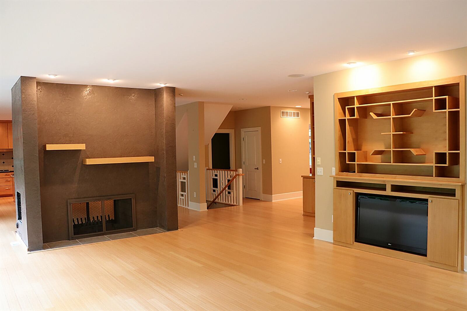 A 2-sided masonry, wood-burning fireplace divides the kitchen from the family room. Facing the family room, the fireplace has two off-setting wood mantel shelves that complement the flooring. Built-in media display has an art-deco wooden design and nearby are built-in shelves and cabinetry. CONTRIBUTED PHOTO BY KATHY TYLER