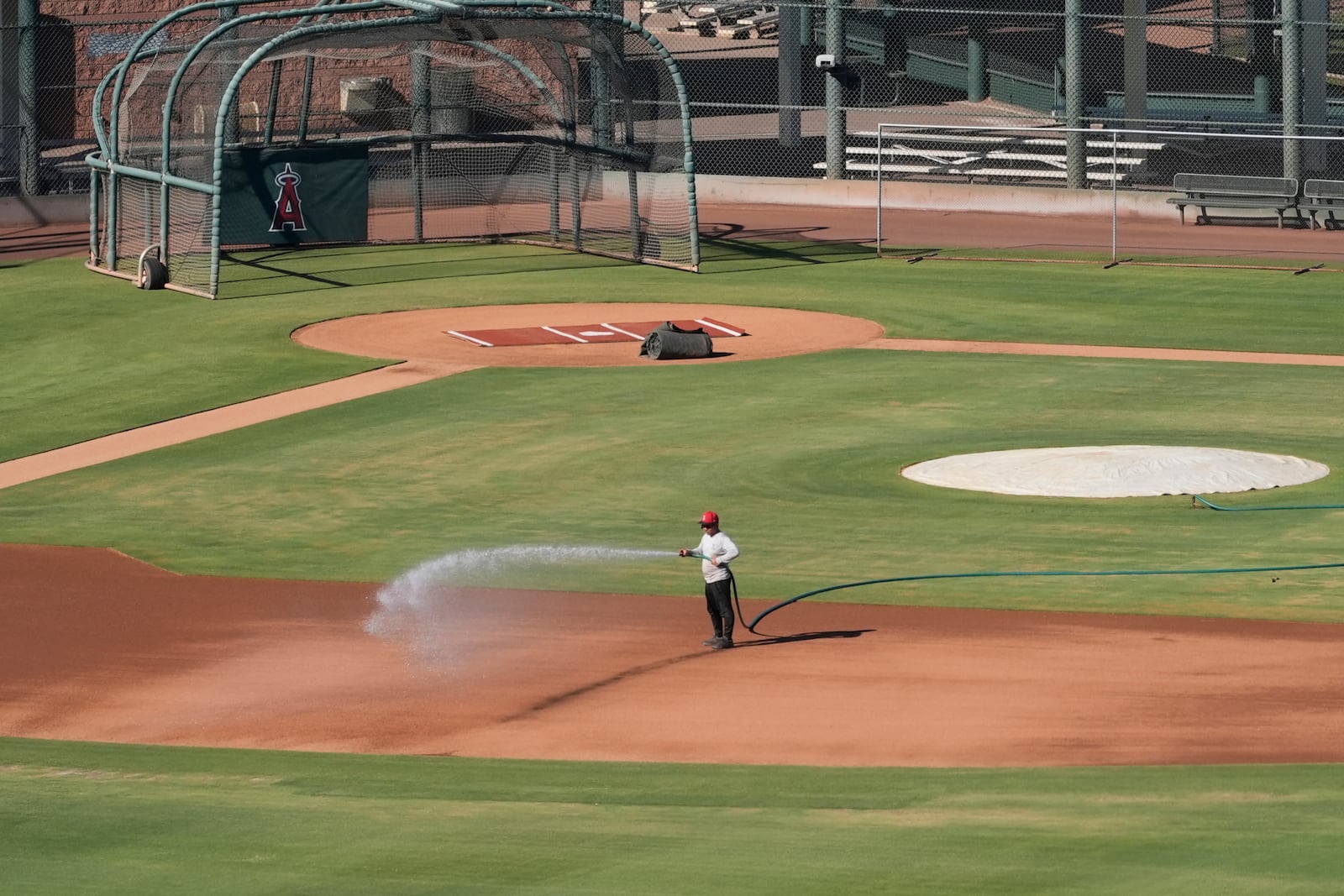 A grounds crew worker waters one of the baseball fields at the Los Angeles Angels training complex Tuesday, Sept. 24, 2024, in Tempe, Ariz. (AP Photo/Ross D. Franklin)