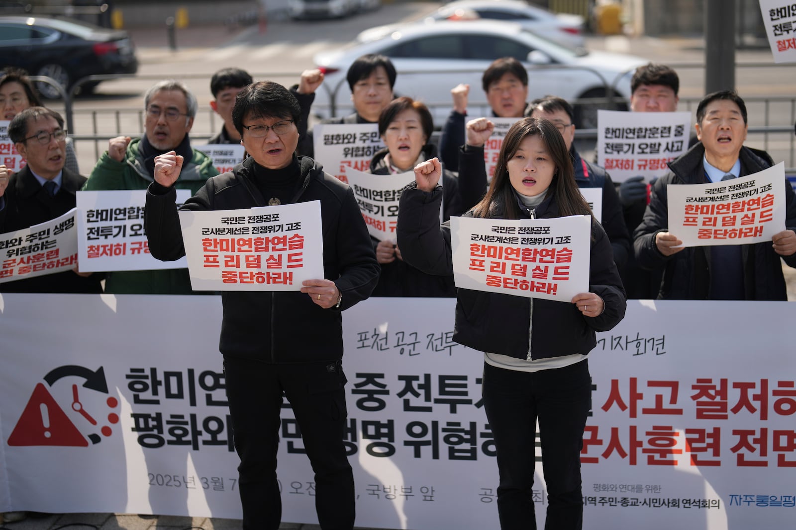 Protesters shout slogans during a press conference demanding to stop the upcoming Freedom Shield military exercise between the U.S. and South Korea and also demanding to investigate the cause thoroughly about fighter jets accidentally dropped eight bombs on a civilian area, in Seoul, South Korea, Friday, March 7, 2025. Banners read "Stop the Freedom Shield military exercise between the U.S. and South Korea." (AP Photo/Lee Jin-man)