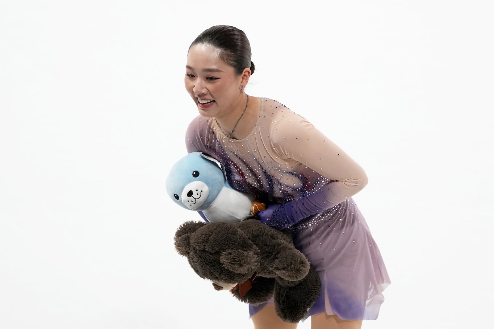 Wakaba Higuchi, of Japan, picks up gifts from fans after competing in the women's free skating segment at the ISU Grand Prix of Figure Skating, Saturday, Nov. 2, 2024, in Angers, France. (AP Photo/Aurelien Morissard)