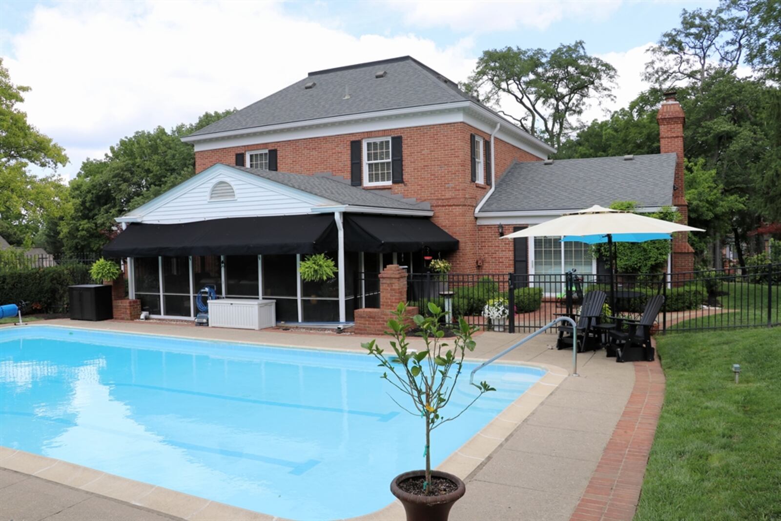 The tree-lined backyard garden oasis features an in-ground, salt-water swimming pool and sun deck. 