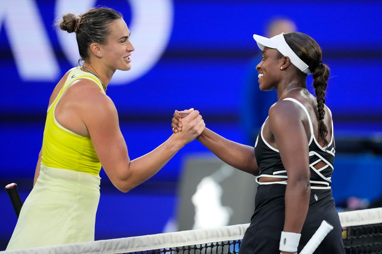 Aryna Sabalenka, left, of Belarus is congratulated by Sloane Stephens of the U.S. following their first round match at the Australian Open tennis championship in Melbourne, Australia, Sunday, Jan. 12, 2025. (AP Photo/Vincent Thian)