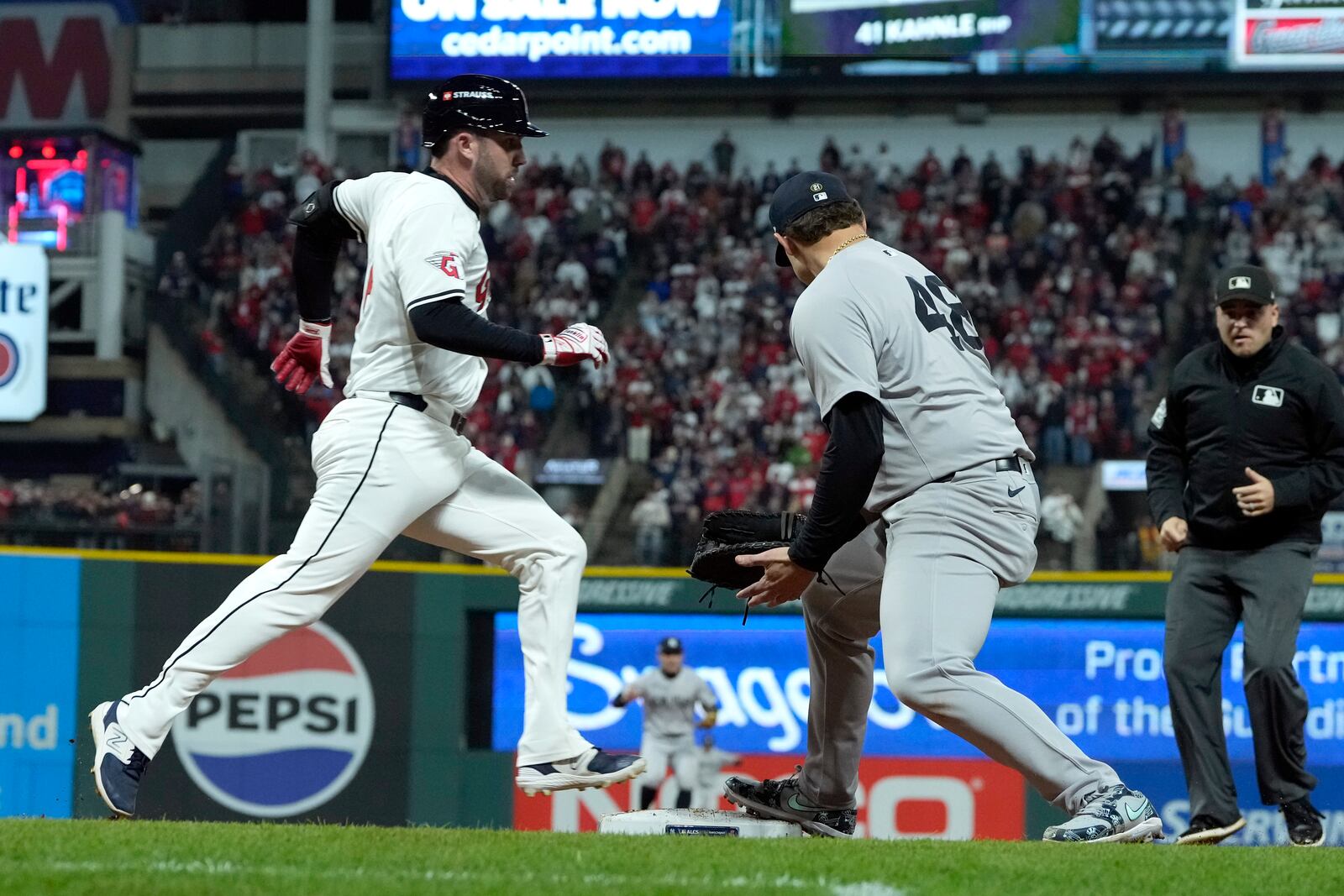 Cleveland Guardians' David Fry, left, is safe at first as New York Yankees first baseman Anthony Rizzo looks back for a errant throw from pitcher Mark Leiter Jr. during the eighth inning in Game 4 of the baseball AL Championship Series Friday, Oct. 18, 2024, in Cleveland. (AP Photo/Godofredo A. Vasquez)