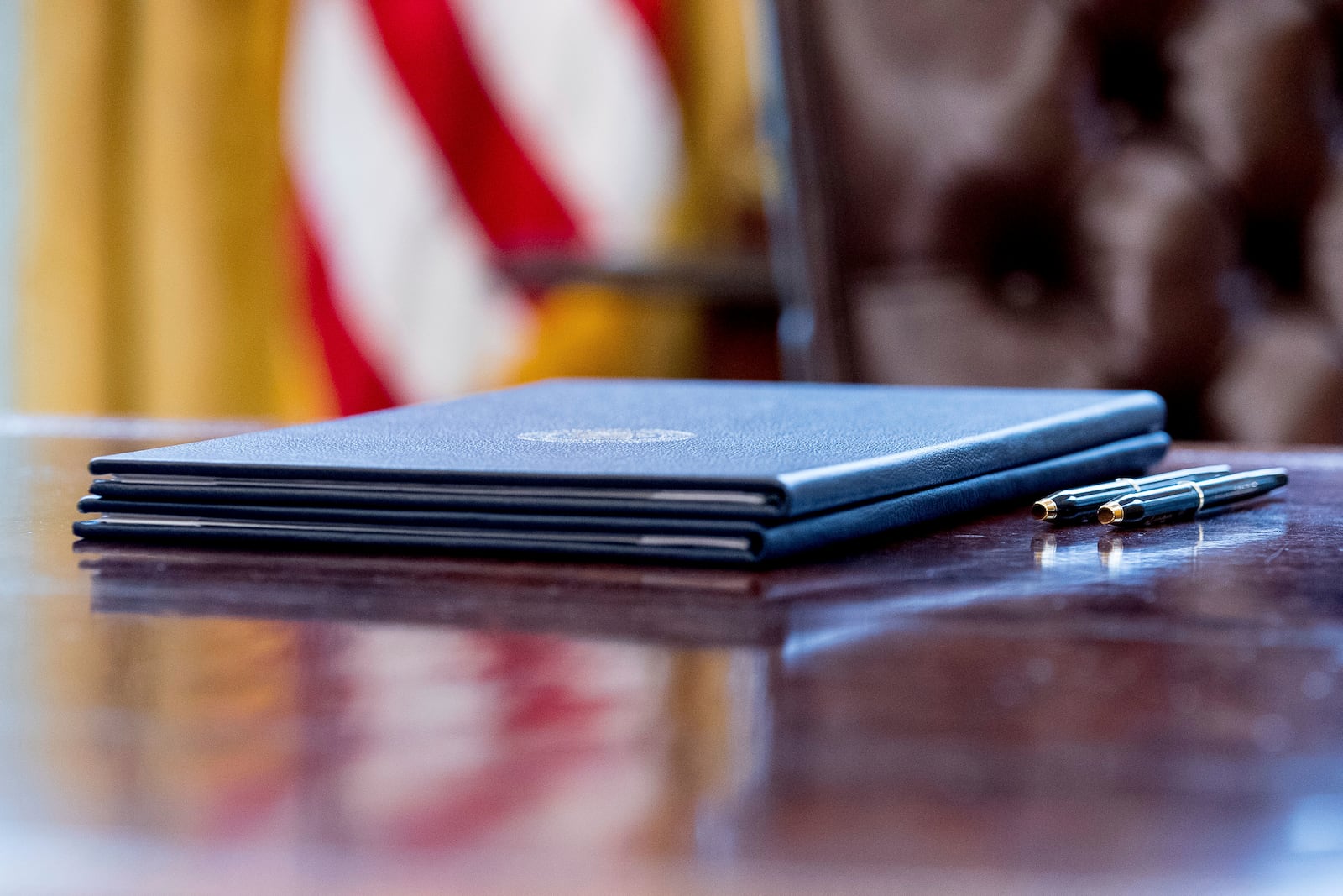 FILE - Executive orders regarding trade are placed on the desk for President Donald Trump to sign in the Oval Office at the White House, March 31, 2017, in Washington. (AP Photo/Andrew Harnik, File)