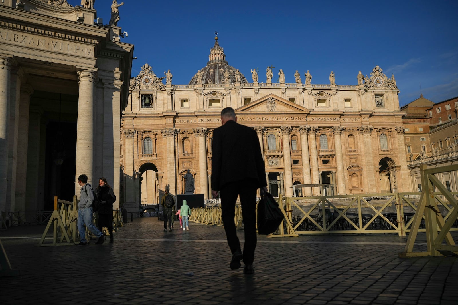 People walk in St. Peter's Square at The Vatican, Sunday, Feb. 23, 2025, ahead of a mass for the Jubilee of Deacons in St. Peter's Basilica that was supposed to be presided over by Pope Francis who was admitted at Rome's Agostino Gemelli Polyclinic over a week ago and is in critical conditions. (AP Photo/Alessandra Tarantino)