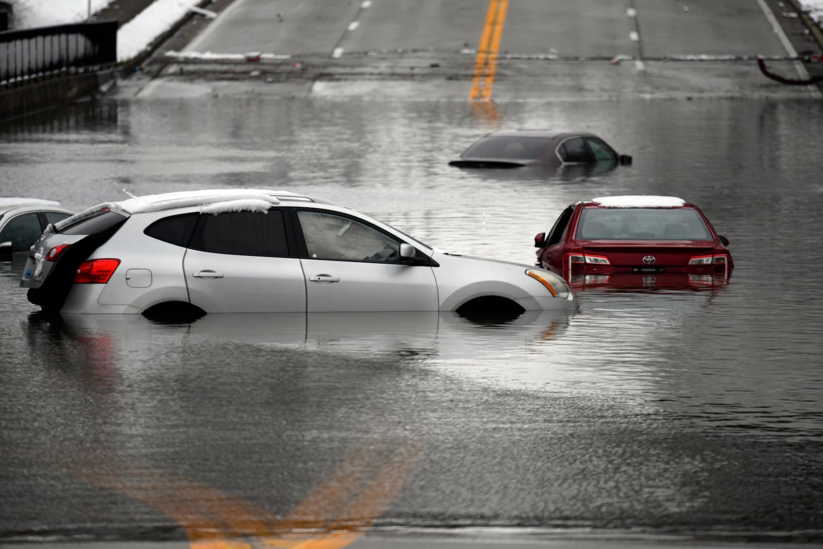 Cars sit in floodwaters at a railroad underpass in Louisville, Ky., Sunday, Feb. 16, 2025. (AP Photo/Timothy D. Easley)