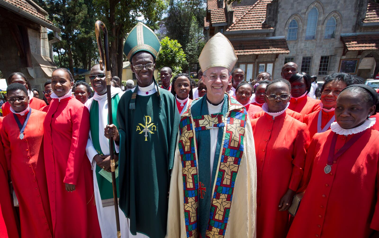 FILE - The Archbishop of Canterbury Justin Welby, center-right, accompanied by Archbishop of Kenya Eliud Wabukala, center-left, poses for a photograph with members of the choir after conducting a service at the All Saints Cathedral in Nairobi, Kenya, Sunday, Oct. 20, 2013. (AP Photo/Ben Curtis, File)