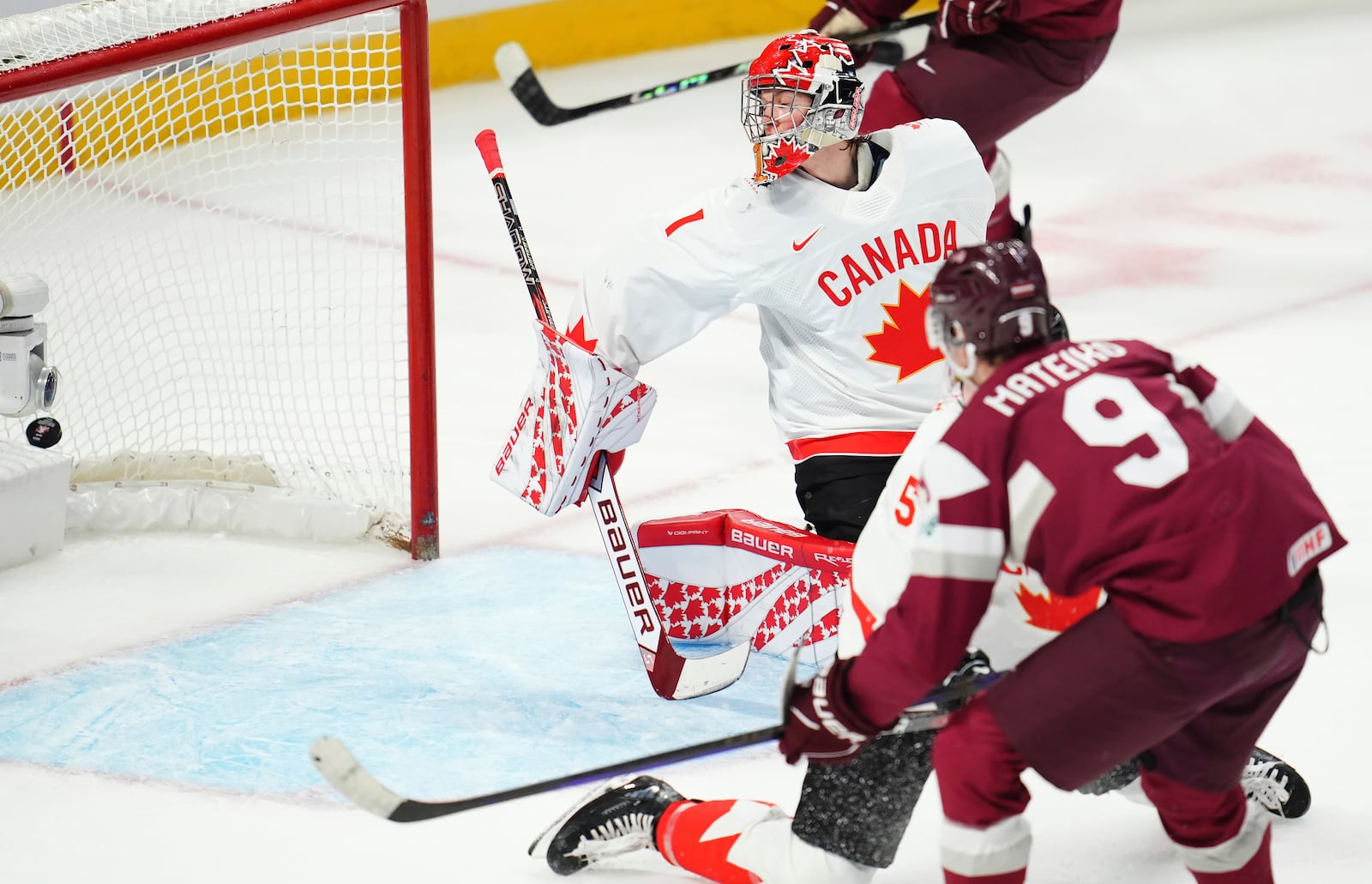 Latvia's Eriks Mateiko (9) scores on Canada goaltender Jack Ivankovic (1) during the third period of a IIHF World Junior Hockey Championship preliminary round game in Ottawa, Ontario on Friday, Dec. 27, 2024. (Sean Kilpatrick/The Canadian Press via AP)