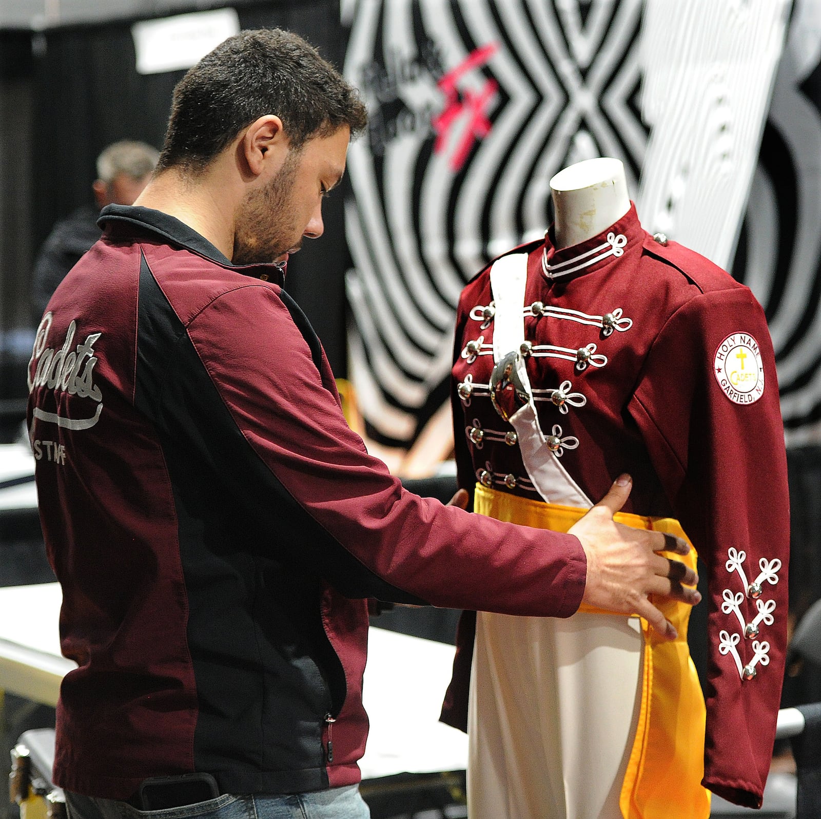 Israel DeMello, Operations Manager at The Cadets, sets up a display Wednesday 6, 2022 for the upcoming winter guard international world championship at the University of Dayton Arena. MARSHALL GORBY\STAFF