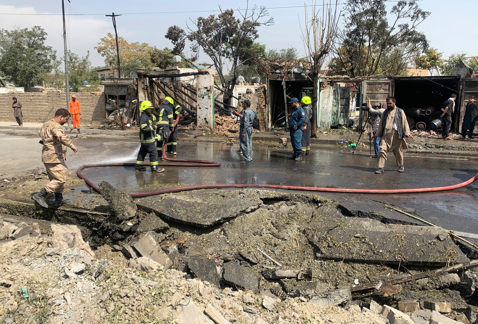 Afghan security personnel and municipality workers work at the site of an explosion in Kabul, Afghanistan, Wednesday, Sept. 9, 2020. Spokesman for Afghanistan's Interior Ministry said the bombing that targeted the convoy of the country's first vice president on Wednesday morning killed several people and wounded more than a dozen others, including several of the vice president's bodyguards. (AP Photo/Rahmat Gul)