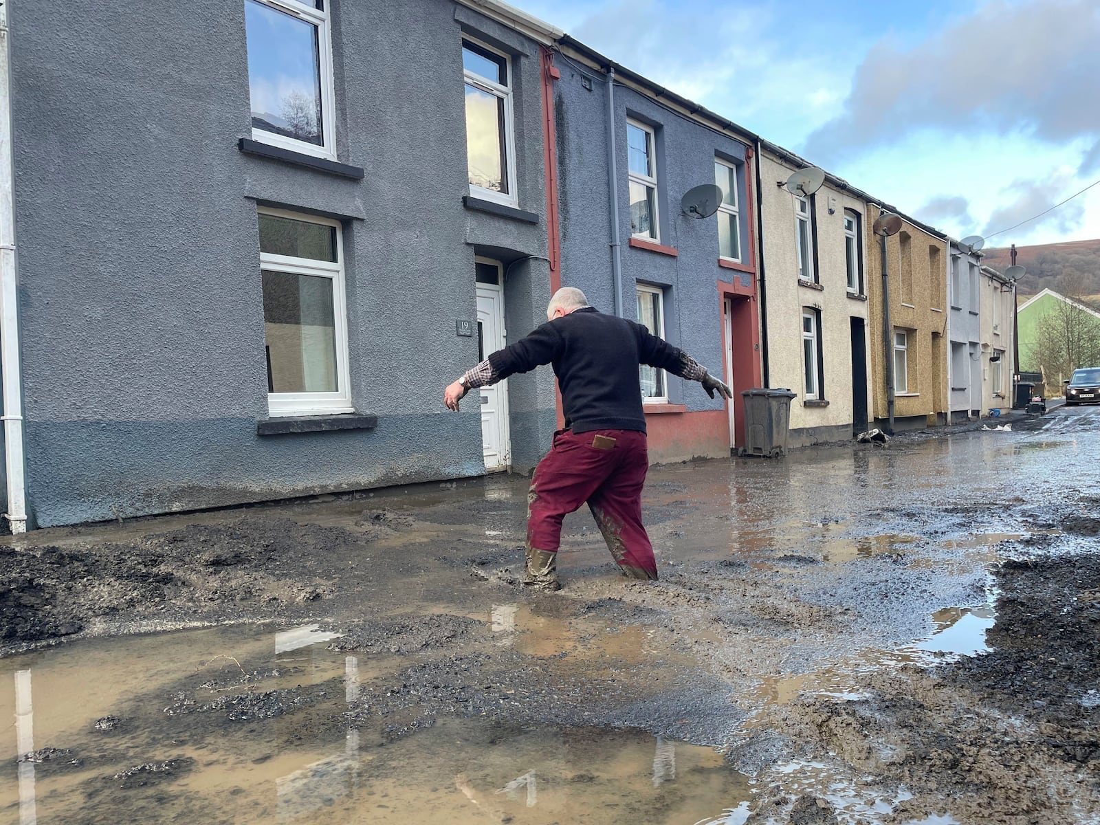 Rob, surname not given, walks through flood water as an apparent mud slide has forced people from their homes as Storm Bert continues to cause disruption, in Cwmtillery, Wales, Monday, Nov. 25, 2024. (George Thompson/PA via AP)