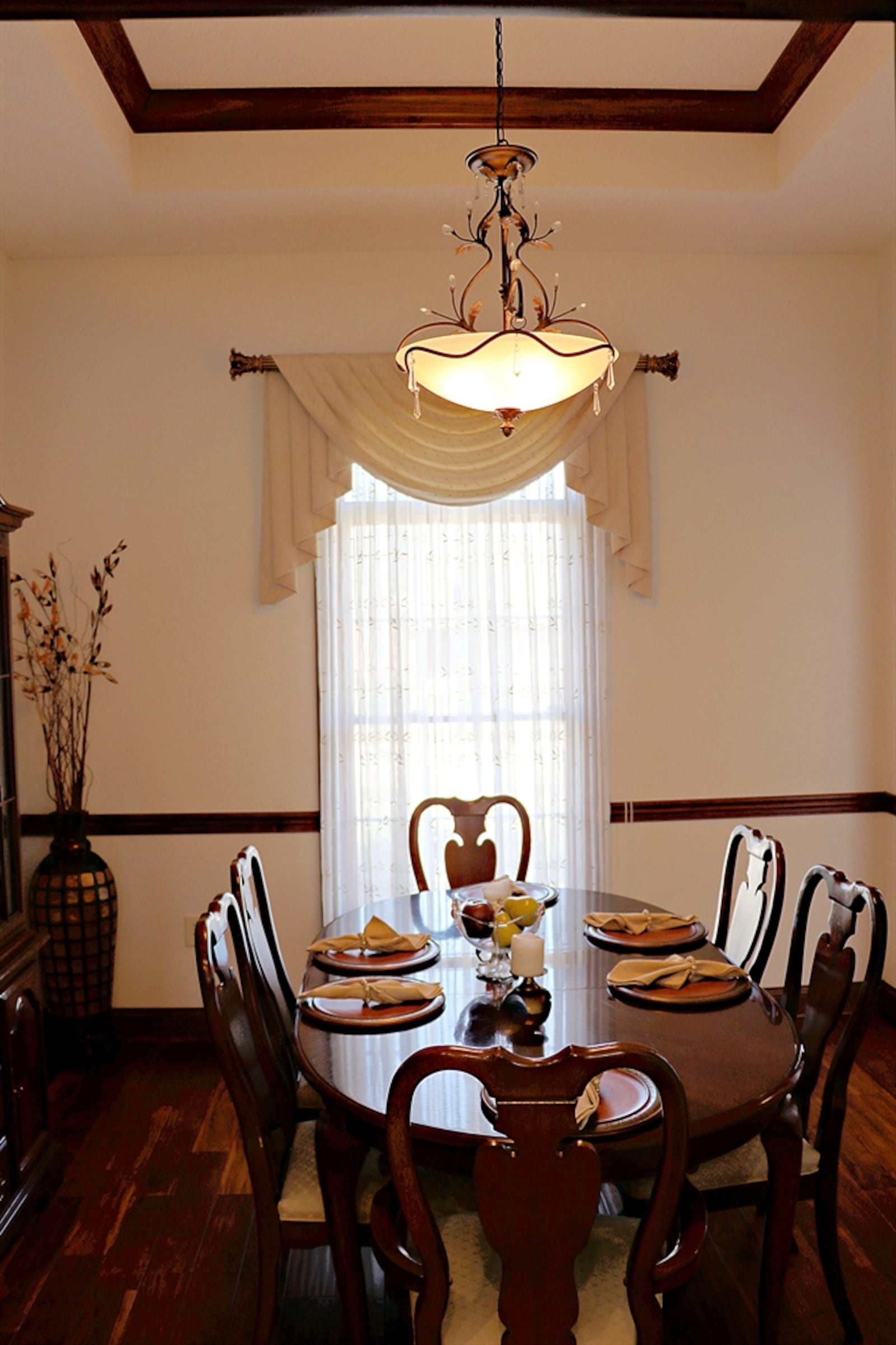 The dining room has a tray ceiling with a hanging light fixture and chair rail.