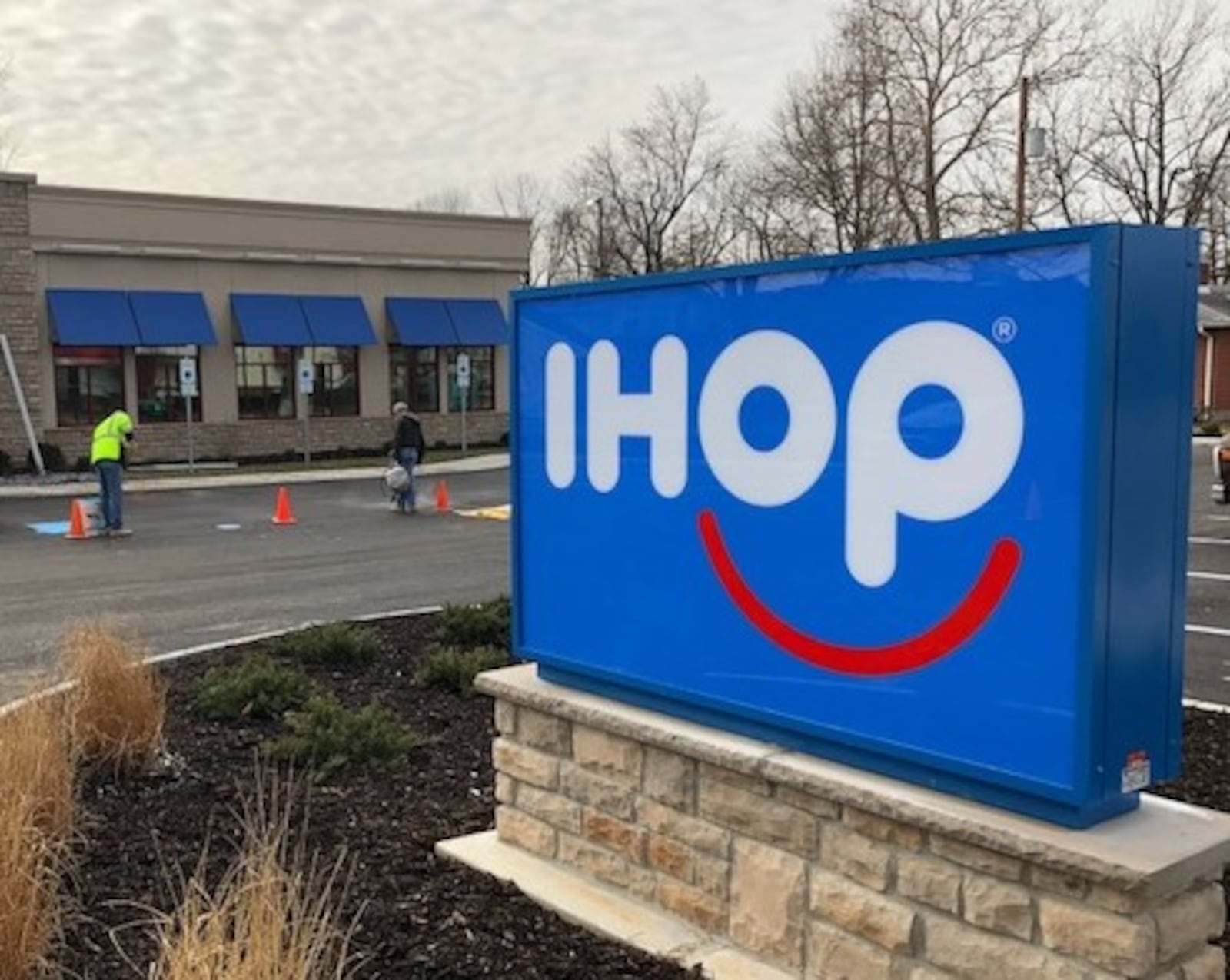 Workers put the finishing touches on the parking lot of the new IHOP near Miller Lane in Vandalia. MARK FISHER/STAFF