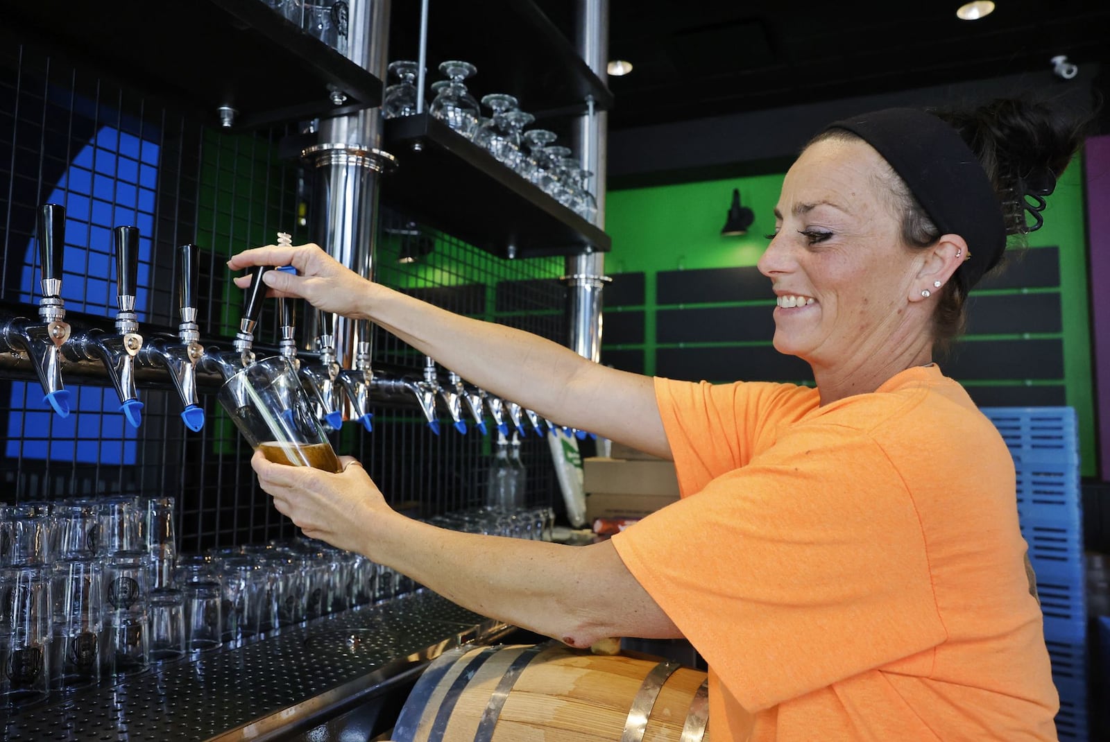 Owner Sarah Lister pours a beer at the new Voodoo Brew Pub opening at Streets of West Chester in the former Mitchell's Fish Market location. NICK GRAHAM/STAFF