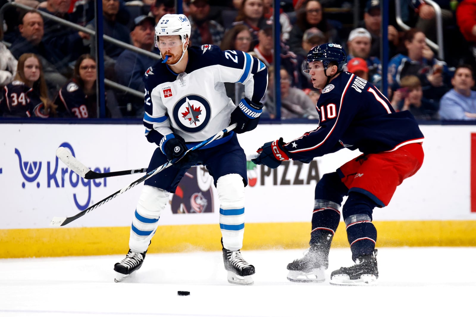 Winnipeg Jets forward Mason Appleton, left, passes the puck in front of Columbus Blue Jackets forward Dmitri Voronkov during the second period of an NHL hockey game in Columbus, Ohio, Friday, Nov. 1, 2024. (AP Photo/Paul Vernon)