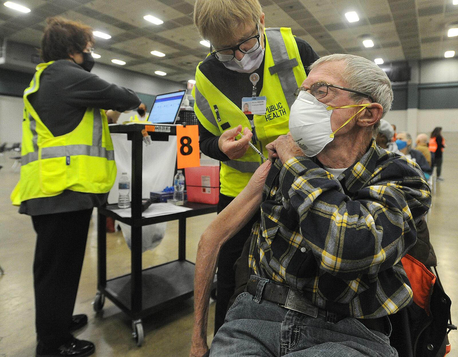 Michael Stapleton, 80, of Tipp City, receives his COVID-19 vaccination from a healthcare worker Wednesday morning, Jan. 20, 2021 at the Dayton Convention Center.