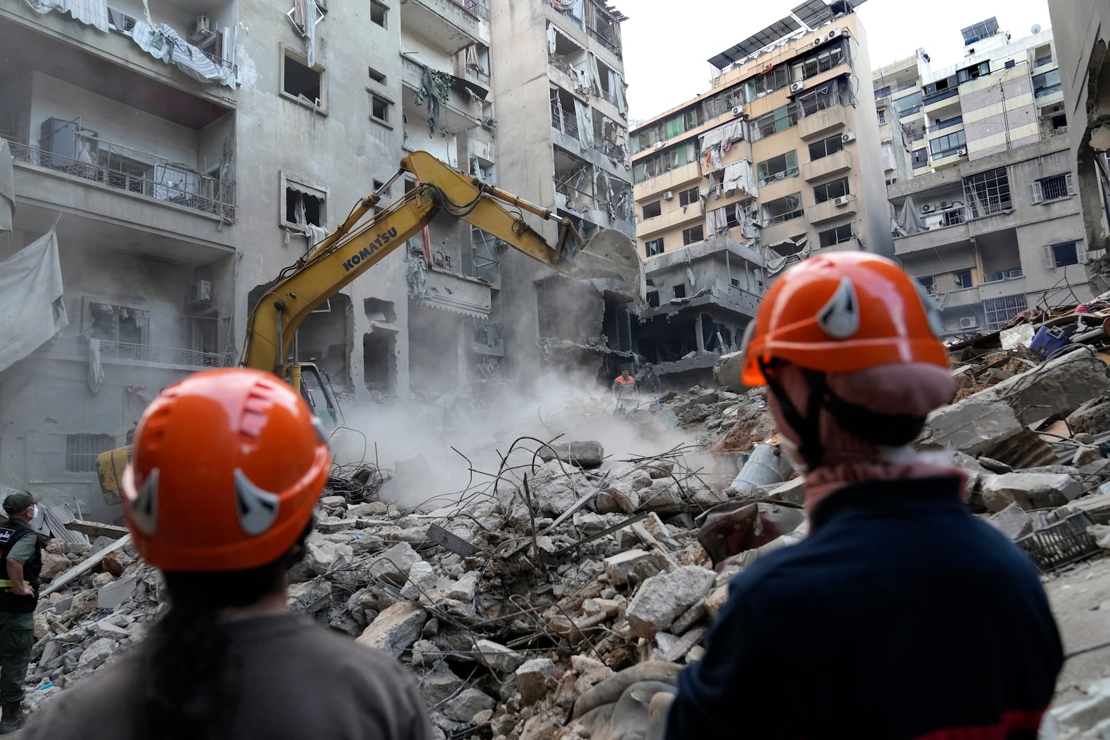 Rescue workers use an excavator to clear the rubble of destroyed buildings as they search for victims at the site of Thursday's Israeli airstrike, in Beirut, Lebanon, Friday, Oct. 11, 2024. (AP Photo/Hussein Malla)