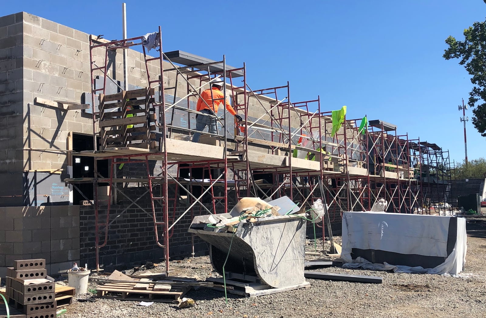 Construction workers affix veneers to the exterior walls of the new West Carrollton Early Childhood Center on Friday, Sept. 24, 2021. The ECC will house the school district's preschool, kindergarten and first grade students starting in fall 2022.