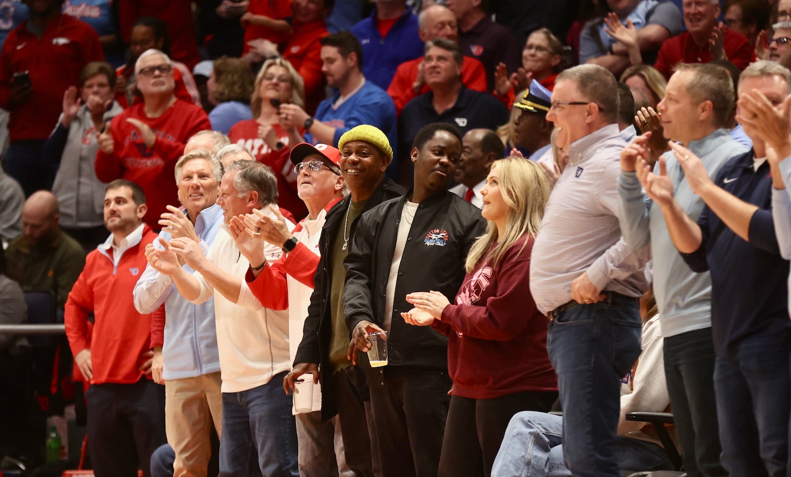 Comedian Dave Chappelle (yellow hat) watches Dayton play Saint Louis on Tuesday, March 4, 2025, at UD Arena. Chappelle, a longtime Yellow Springs resident, visited UD Arena for the first time. David Jablonski/Staff