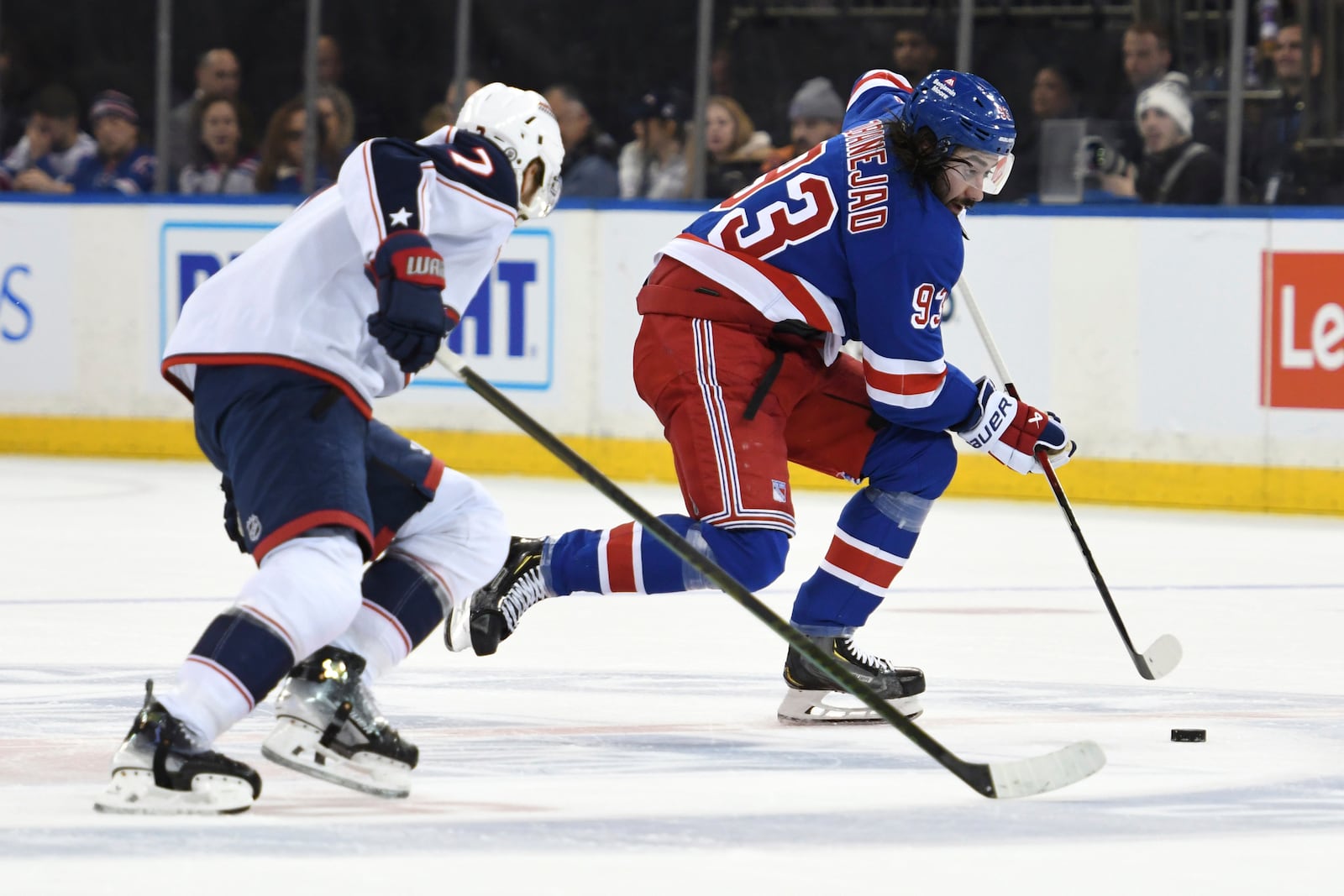 New York Rangers' Mika Zibanejad, right, skates with the puck against Columbus Blue Jackets' Sean Kuraly, left, during the second period of an NHL hockey game Saturday, Jan. 18, 2025, in New York. (AP Photo/Pamela Smith)